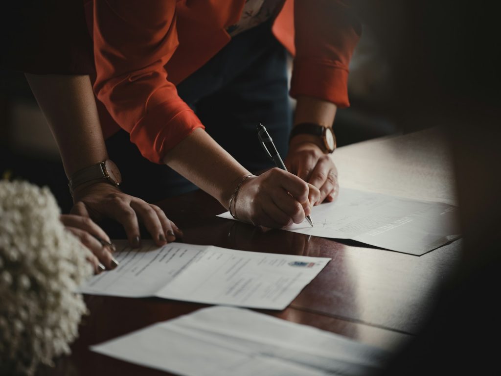 A pen and prepared documents on a desk, ready to be signed at a notary appointment