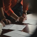 A pen and prepared documents on a desk, ready to be signed at a notary appointment